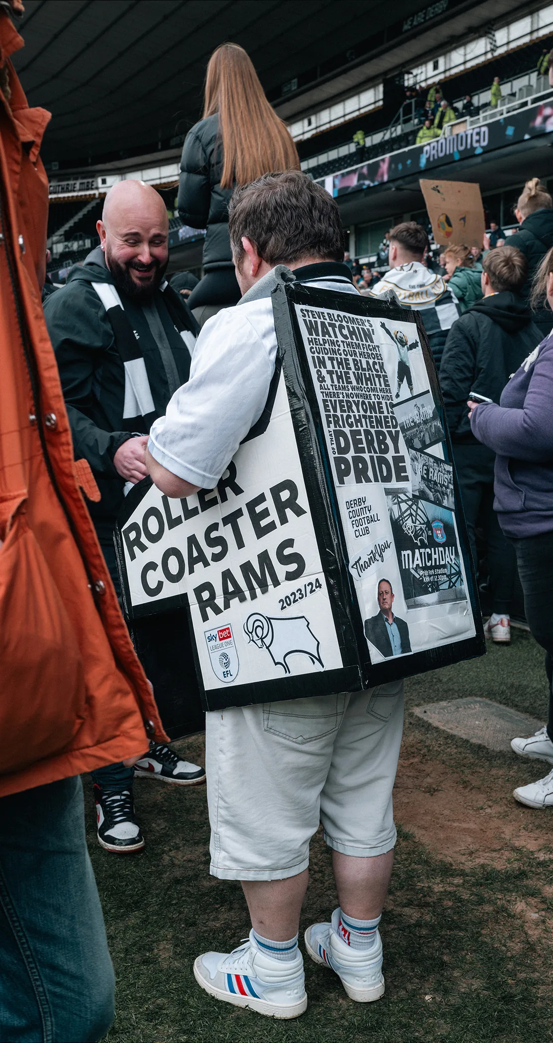 Supporter holding a Roller Coaster Rams matchday paper, Derby