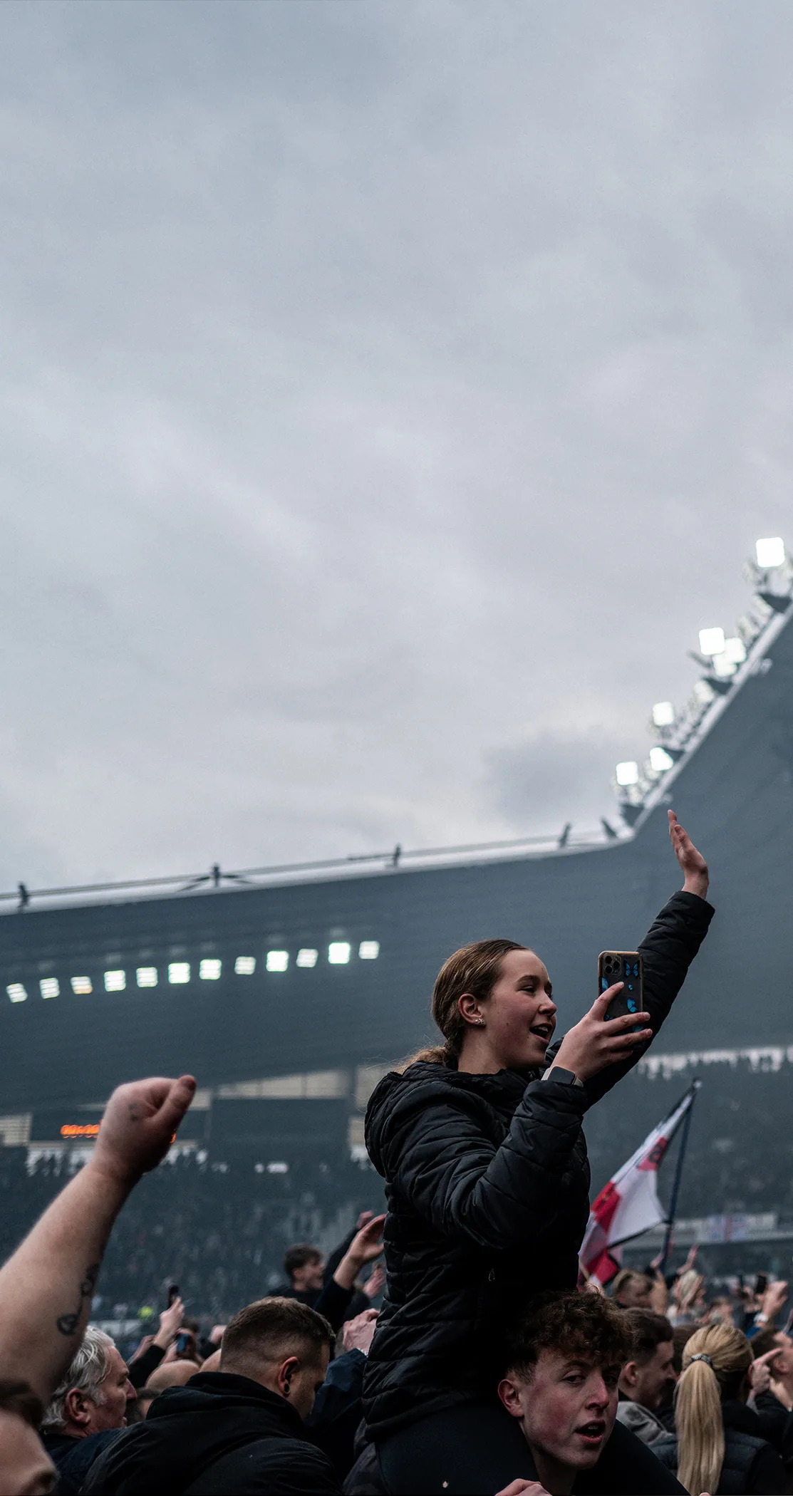 Supporter filming on a phone amid the crowd, Pride Park