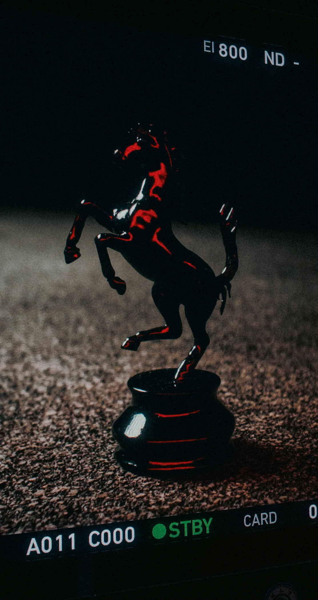A prancing horse figurine framed on a camera monitor reading standby, Lights Out
