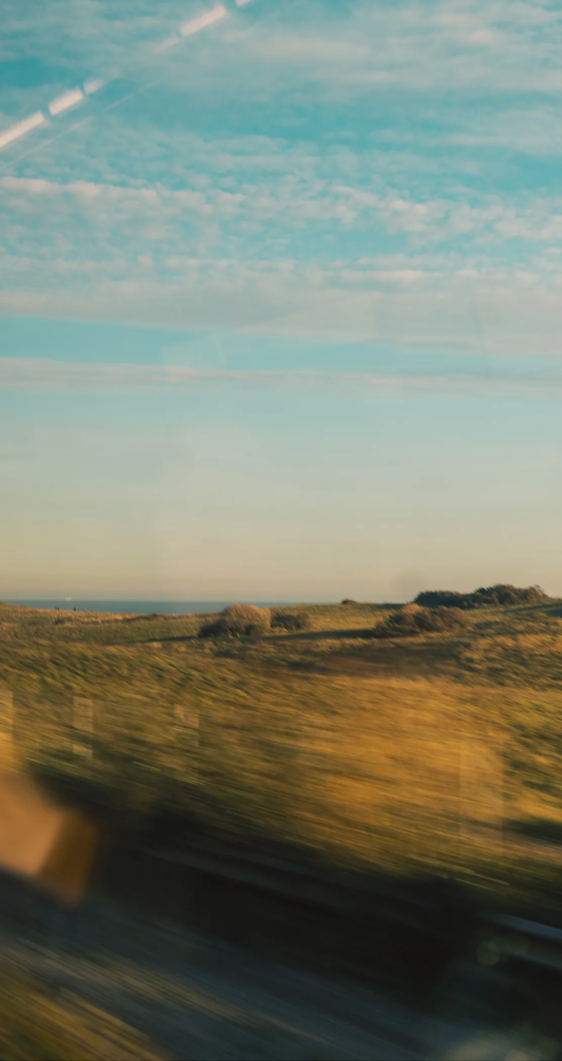 Motion-blurred dunes and coastline with a vapour trail, Margate