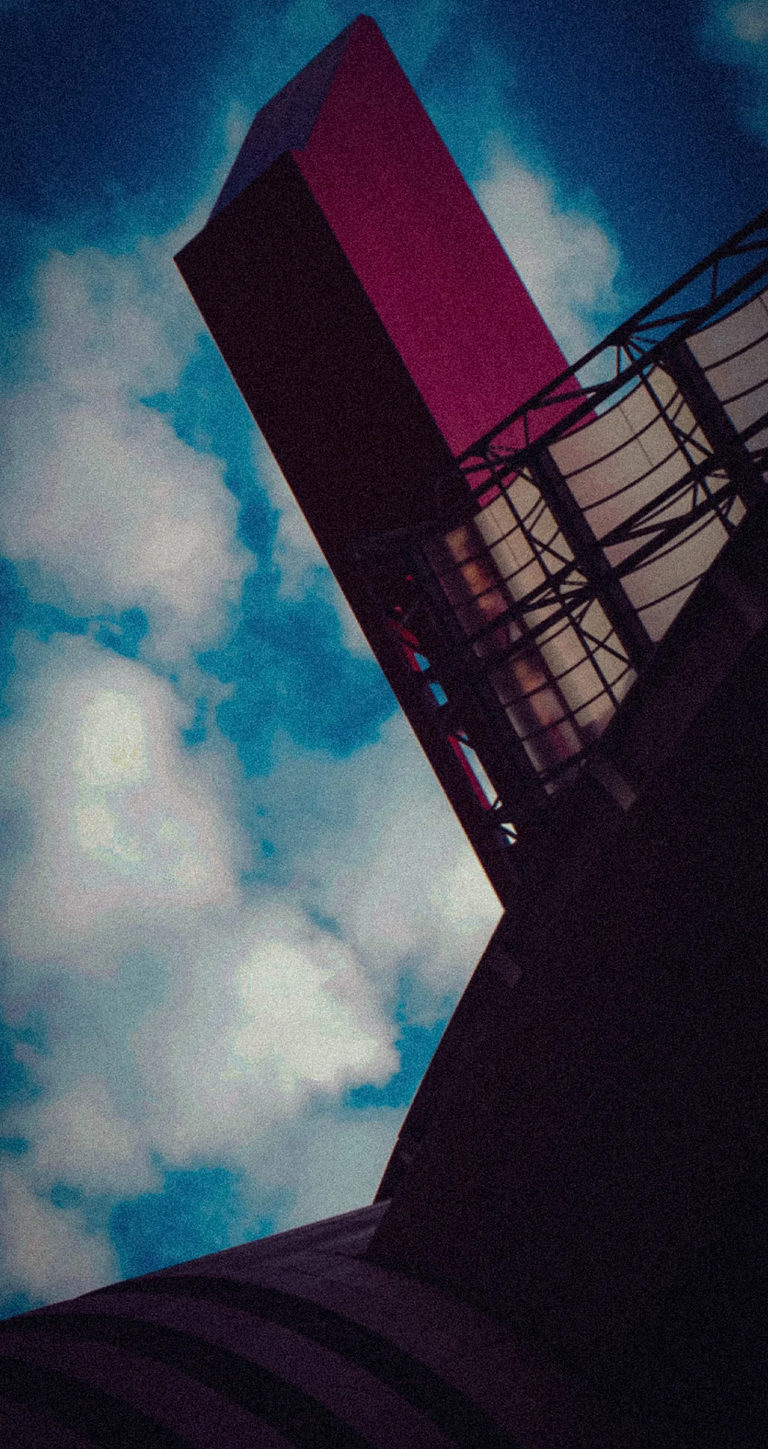 One of the spiral ramp towers of San Siro against blue sky and cloud