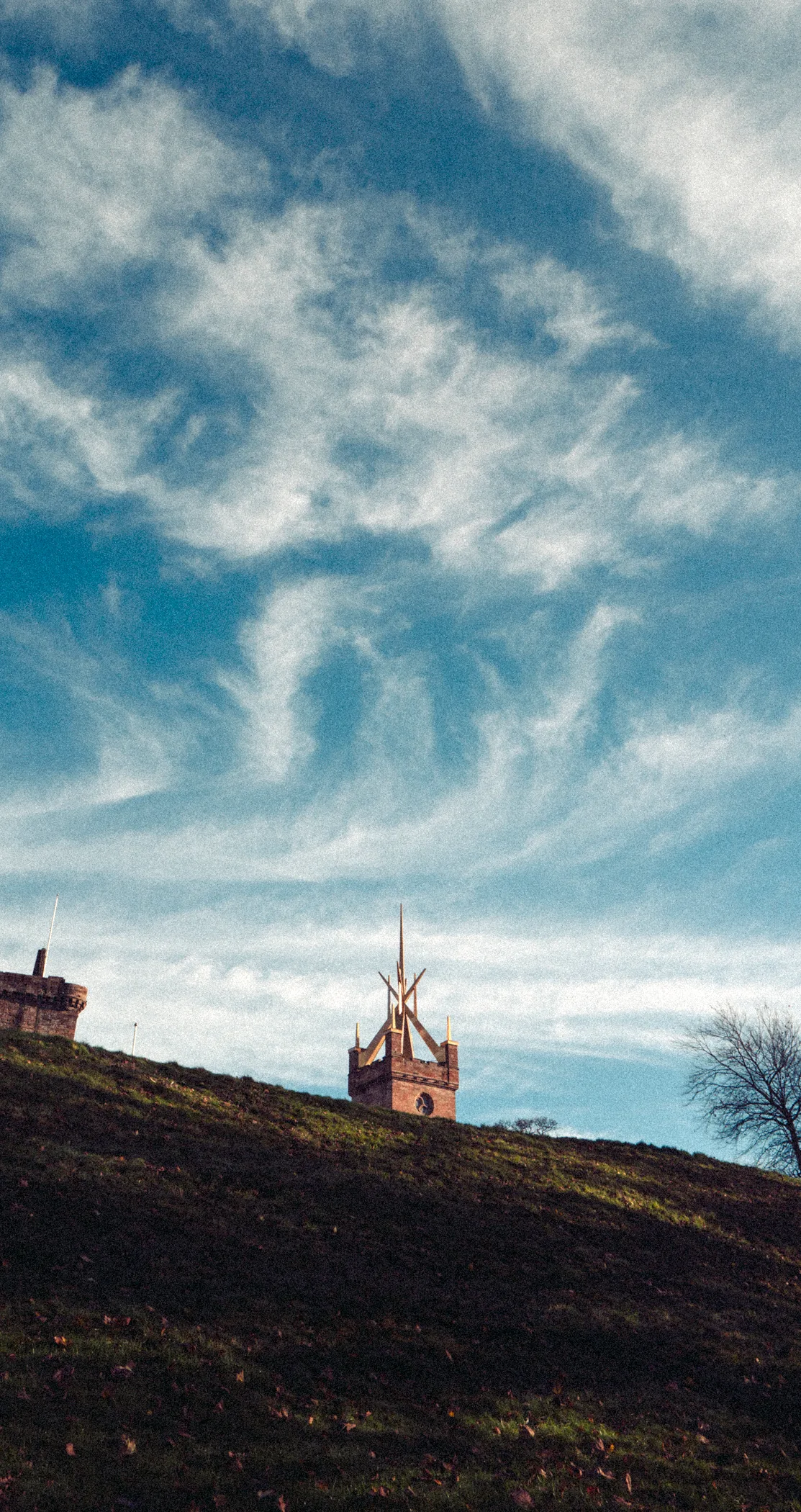 The crown spire of St Michael’s rising over a dark hill beneath swirling cloud, Linlithgow