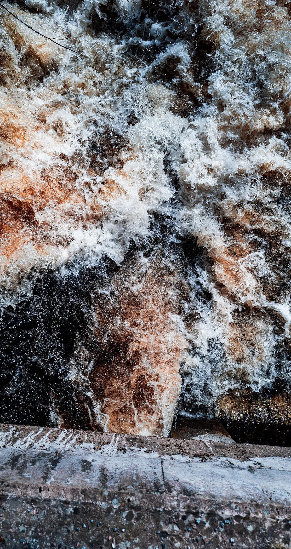 Ice, rust and white foam on a rocky shore, Sweden